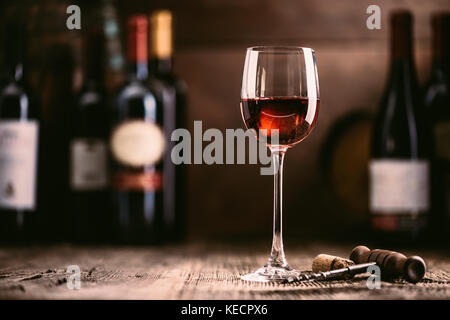 Esperienza di degustazione in cantina rustica e wine bar: vino rosso in vetro e collezione di vini eccellenti sullo sfondo Foto Stock