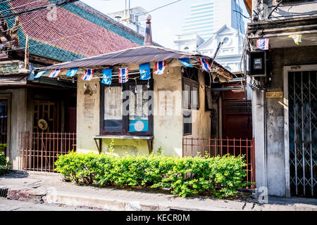 Un vecchio stile thai house si siede di fronte a un grattacielo moderno in una tranquilla strada a Bangkok in Tailandia del sud est asiatico. Foto Stock