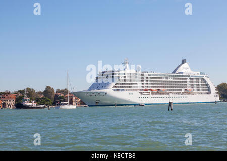 La nave da crociera Sevem Mari Voyager trainato in Venezia, Italia da un rimorchiatore attraverso Basino San Marco 0n la sua strada per il porto passeggeri con il rivestimento Foto Stock