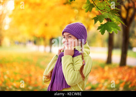 Sorridente ragazza adolescente rilassante in autunno park giallo.giallo.autunno Ritratto di bambino in maple leaf Foto Stock