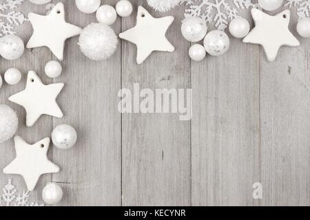 Angolo di natale confine con shabby chic argilla fatti a mano ornamenti su un rustico in legno grigio sfondo Foto Stock