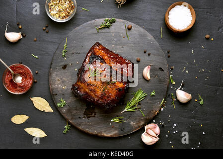 Barbecue di carne di maiale, carne alla griglia su sfondo scuro. vista superiore Foto Stock