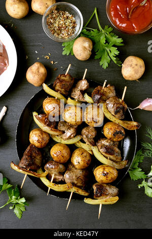 Fegato di pollo e verdure spiedini su sfondo nero, vista dall'alto Foto Stock