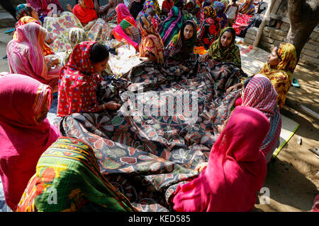 Le donne rurali rendono nakshi kantha, un tipo di quilt ricamato in un villaggio di jessore in Bangladesh. Foto Stock