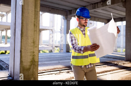Immagine del sito in costruzione ingegnere guardando al plan Foto Stock