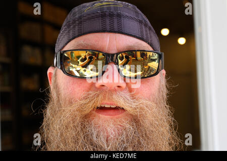 Mann mit langem Bart und Sonnenbrille , lächelt, Ritratto Foto Stock