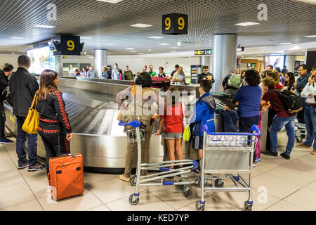 Lisbona Portogallo,Aeroporto Humberto Delgado,LIS,Aeroporto Portela,ritiro bagagli,carosello,bagagli,passeggeri passeggeri motociclisti,famiglia genitori p Foto Stock