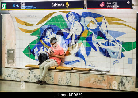 Lisbona Portogallo,Metro de Lisboa,metro,metropolitana,trasporto di massa,stazione di Saldanha,piattaforma,arte pubblica,azulejos,piastrelle dipinte,Luis Felipe de Abreu,panca,man m Foto Stock