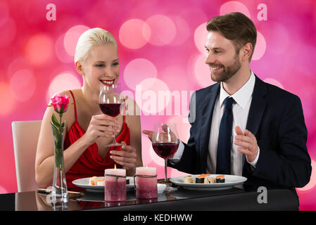 Ritratto di una giovane coppia di consumare la cena in un ristorante di sfondo bokeh di fondo Foto Stock
