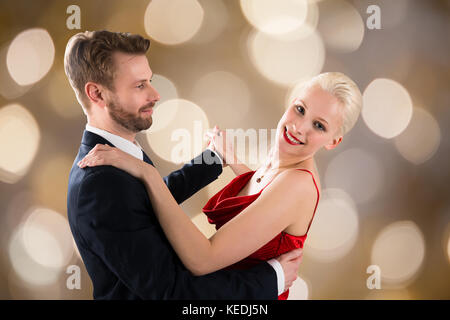 Ritratto di giovane coppia felice danza su sfondo bokeh di fondo Foto Stock