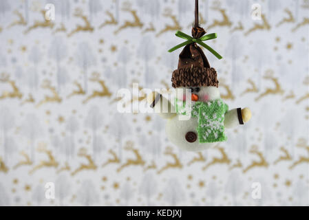 Fotografia di Natale immagine della decorazione di Natale di riagganciare di carino pupazzo di neve in hat sciarpa con oro glitter renne xmas incarto lo sfondo della carta Foto Stock