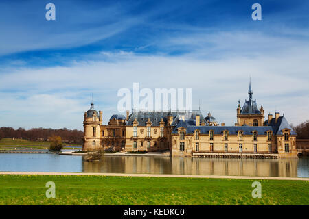 Chateau de Chantilly castello circondato da acqua calma di stagno, Francia Foto Stock