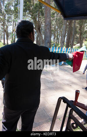 Ooty, Tamil Nadu, India, 22 marzo 2015 : nilgiri ferrovia di montagna. operaio ferroviario, pointsman holding bandiera rossa sulla stazione ferroviaria Foto Stock