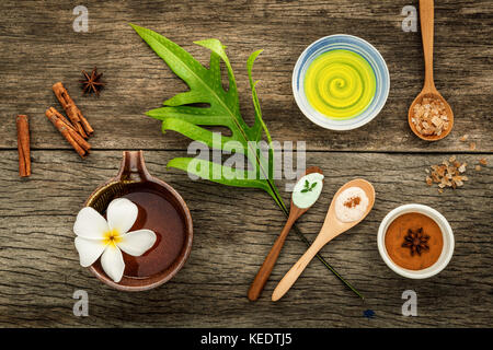 Gli avocadi lascia con la natura spa ingredienti essiccati bael indiana ,cannella in polvere ,bastoncini di cannella ,olio aromatico ,anice stellato e sale marino su rustiche bac Foto Stock