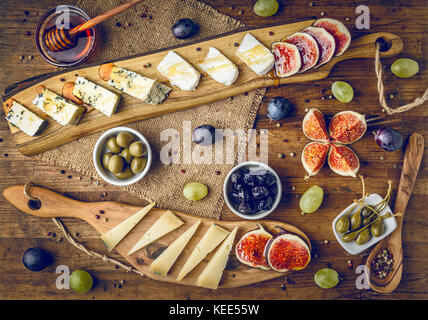 Piatto di formaggi italiani con figure, olive, uva e miele tonica Foto Stock