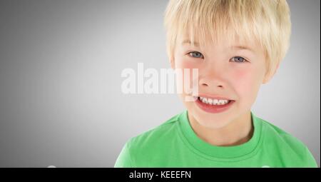 Composito Digitale del ragazzo biondo contro uno sfondo grigio con verde t-shirt Foto Stock