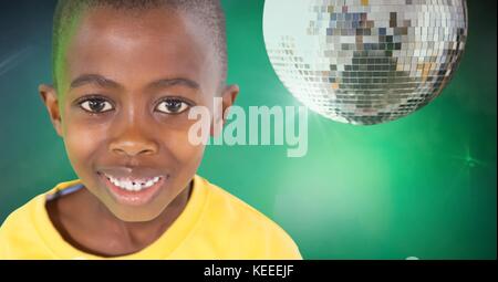 Composito Digitale del ragazzo contro lo sfondo di colore verde con palla da discoteca party Foto Stock