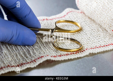 Forbici chirurgiche su un bendaggio, immagine concettuale Foto Stock