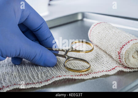 Forbici chirurgiche su un bendaggio, immagine concettuale Foto Stock