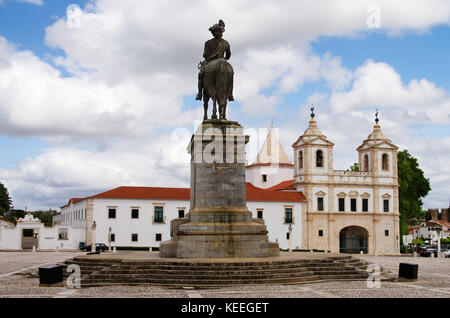 Statua di re Giovanni IV (d. joao iv) rivolta verso la chiesa e il monastero di agostinhos sotto un bianco e blu cielo velato. vila vicosa, Alentejo, Portogallo. Foto Stock