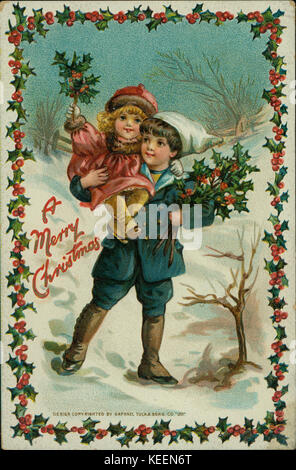 Cartolina di Natale con un giovane ragazzo che trasportano un covone di holly in un braccio e bambina, anche azienda holly rami, in altri, circondato da un bordo di agrifoglio e con le parole di un Buon Natale. Foto Stock