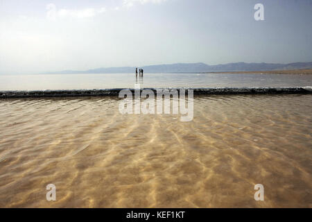 Sharafkhaneh, Sharafkhaneh, Iran. 9 Ott 2009. La gente locale è vista camminare attraverso il lago.Sharafkhaneh si trova sul lago Urmia, un lago salato con oltre 5000 chilometri quadrati di diametro e più di 100 piccole isole rocciose. È una riserva della biosfera dell'UNESCO che ospita oltre 200 specie di uccelli e molte altre specie di rettili, anfibi e mammiferi, tra cui il cervo giallo iraniano. Il lago si è ridotto da molto tempo e la costruzione di una diga e la recente siccità hanno ridotto significativamente la sua quantità di acqua. L'evaporazione dell'acqua ha aumentato il sal del lago Foto Stock