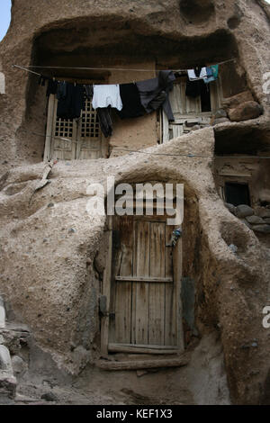 8 maggio 2008 - Kandovan, Provincia di Kandovan Azerbaigian, Iran - vestiti si stanno asciugando fuori di una casa locale.. Il piccolo villaggio di Kandovan (aka Kanvan), nella provincia iraniana dell'Azerbaigian orientale è conosciuto per le sue abitazioni rupestri, non costruite sulle formazioni rocciose, ma scavate nelle rocce vulcaniche stesse. Le formazioni rocciose a forma di cono sono dovute all'erosione dell'acqua della matrice acida porosa, sviluppata dopo l'eruzione del Monte Sahand nel Distretto Centrale della Contea di Osku. Le rocce fungono anche da materiale a basso consumo energetico, mantenendo le case calde in inverno e fresche in estate. A partire da t Foto Stock