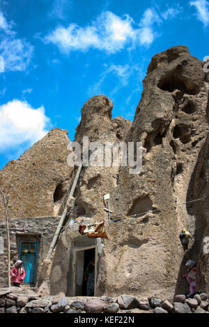 8 maggio 2008 - Kandovan, Provincia di Kandovan Azerbaigian, Iran - UNA donna locale è vista mentre cammina attraverso il villaggio.. Il piccolo villaggio di Kandovan (aka Kanvan), nella provincia di Azerbaigian orientale iraniano è conosciuto per le sue abitazioni di scogliera, non costruito sulle formazioni rocciose, ma scolpito nelle rocce vulcaniche stesse. Le formazioni rocciose a forma di cono sono dovute all'erosione dell'acqua della matrice acida porosa, sviluppata dopo l'eruzione del Monte Sahand nel Distretto Centrale della Contea di Osku. Le rocce fungono anche da materiale a basso consumo energetico, mantenendo le case calde in inverno e fresche in estate Foto Stock