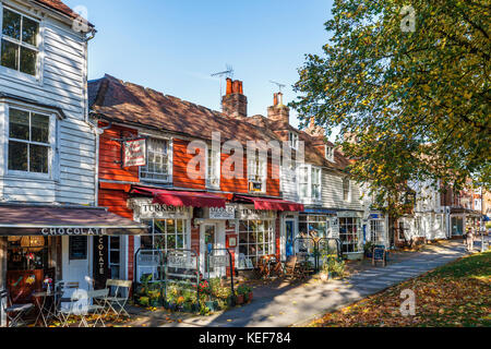 Tenterden, Kent, Regno Unito. Xx oct, 2017. Regno Unito meteo. Una scena di strada di stile tradizionale locale negozi in bianco e rosso edifici clapboard, High Street, Tenterden, Kent, sud-est Inghilterra su un soleggiato tardo autunno il giorno in pezzata di luce solare con alberi in autunno colori. Credito: Graham Prentice/Alamy Live News Foto Stock