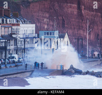 Sidmouth, Regno Unito. 21 ott 2017. Regno Unito Meteo. Onde infrangersi in alto al di sopra della stazione di salvataggio come Brian Storm arriva a Sidmouth, nel Devon. Durante le tempeste, la pietra arenaria rossa della zona si trasforma il mare rosso a Sidmouth. Credit: Foto centrale/Alamy Live News Foto Stock