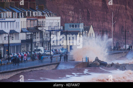 Sidmouth, Regno Unito. 21 ott 2017. Regno Unito Meteo. Onde infrangersi in alto al di sopra della stazione di salvataggio come Brian Storm arriva a Sidmouth, nel Devon. Durante le tempeste, la pietra arenaria rossa della zona si trasforma il mare rosso a Sidmouth. Credit: Foto centrale/Alamy Live News Foto Stock