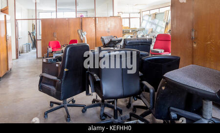 Rotture di sedie da ufficio e cabinet in legno nella camera di deposito Foto Stock