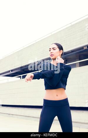 Modello rilasciato. Giovane donna in abbigliamento sportivo di stretching. Foto Stock