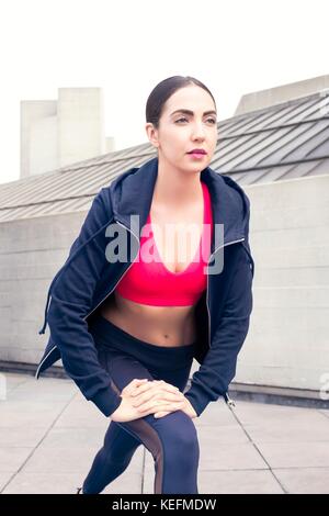 Modello rilasciato. Giovane donna in abbigliamento sportivo di stretching. Foto Stock