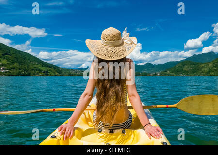 Giovane donna con cappello e bellissimi capelli lunghi rilassante in kayak  sul lago Foto stock - Alamy