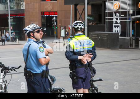 New SouthWales dispone di funzionari di polizia che ride mountain bike mentre di pattuglia, qui raffigurata nel centro cittadino di Sydney Foto Stock