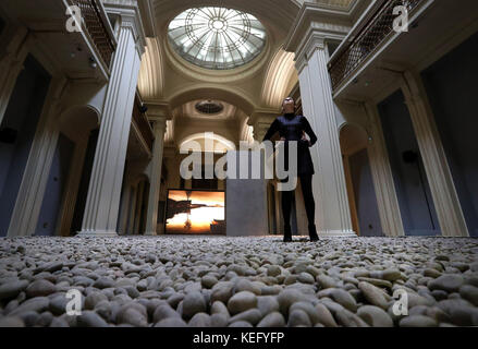 Kathryn Dunlop dell'Università di Edimburgo si erge su migliaia di ciottoli scuri presi dai letti dei fiumi scozzesi che hanno trasformato l'università e Atilde;•S Talbot Rice Gallery come parte del lavoro dell'acclamato artista e regista John Akomfrah nella sua prima mostra personale "Vertigo Sea" in Scozia, che apre sabato 21 e rimane fino alla fine di gennaio 2018. Foto Stock