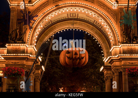 Zucca di Halloween di fronte alla illuminata ingresso principale dei Giardini di Tivoli, Copenhague, Dinamarca Foto Stock