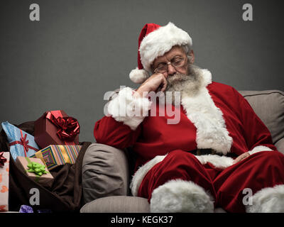 Sleepy santa claus prendendo un pisolino e rilassante sulla poltrona alla vigilia di Natale Foto Stock