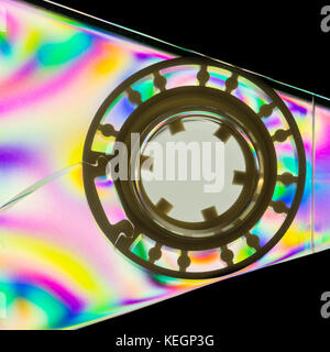 Un colorato di ripresa macro di una cassetta in plastica tiro del nastro attraverso la polarizzazione lineare film. Foto Stock