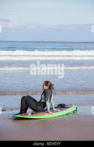 Surf sulla spiaggia Bamburgh, Northumberland, England, Regno Unito Foto Stock