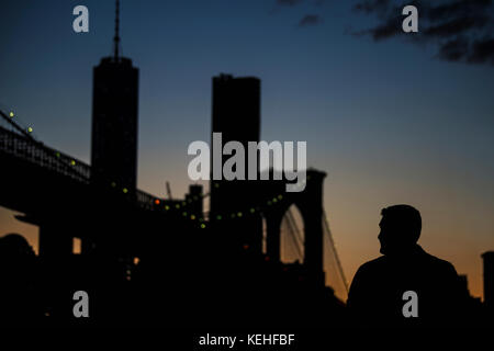 Silhouette di uomo che ammira il ponte di notte Foto Stock