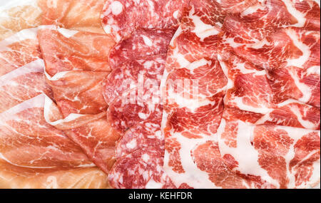 Composizione di antipasti di italiani di salumi. Tipi di salame, prosciutto e prosciutto di Parma a fette, primo piano e vista dall'alto. cibo ackground, la texture e la parete Foto Stock