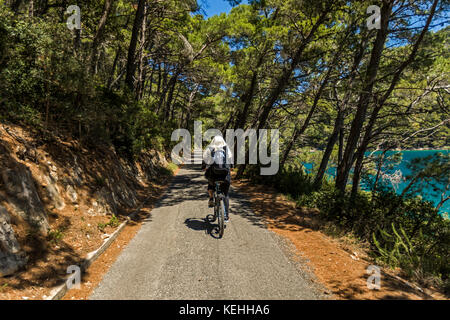 Donna caucasica in bicicletta sul sentiero vicino al lago Foto Stock