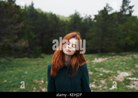 Donna caucasica che indossa cappotto in campo Foto Stock