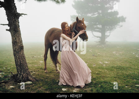 La donna caucasica petting cavallo Foto Stock