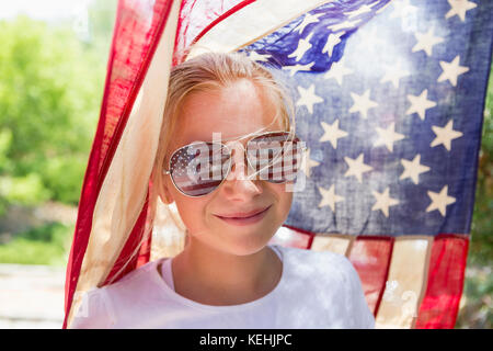 Ragazza caucasica che indossa occhiali da sole bandiera americana Foto Stock