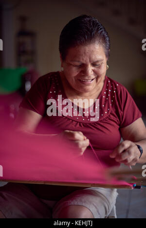 Donna ispanica tessitura tessuto su telaio Foto Stock