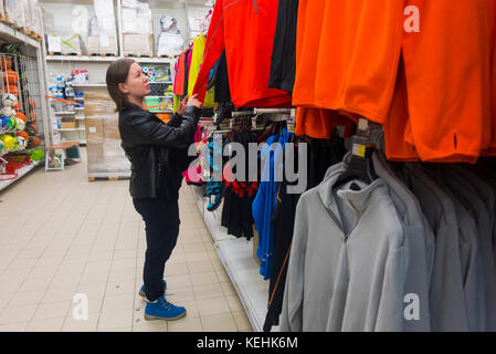 Donna caucasica che esamina la camicia in negozio Foto Stock
