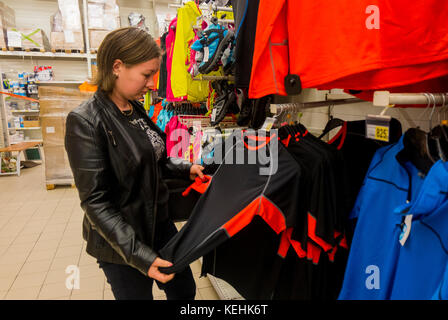Donna caucasica che esamina la camicia in negozio Foto Stock